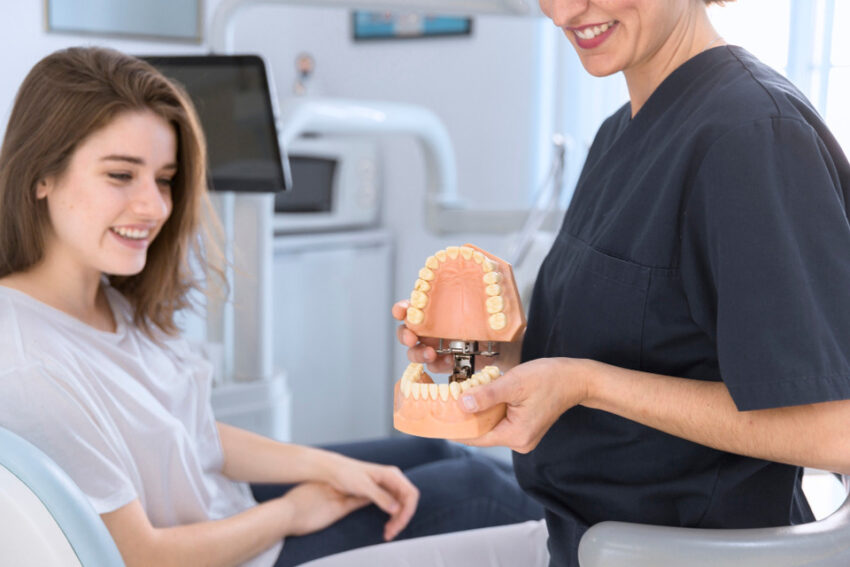 dentystka pokazuje model szczęki pacjentce